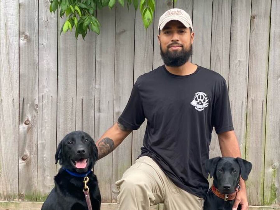 Rolando with two black Labradors during a training session